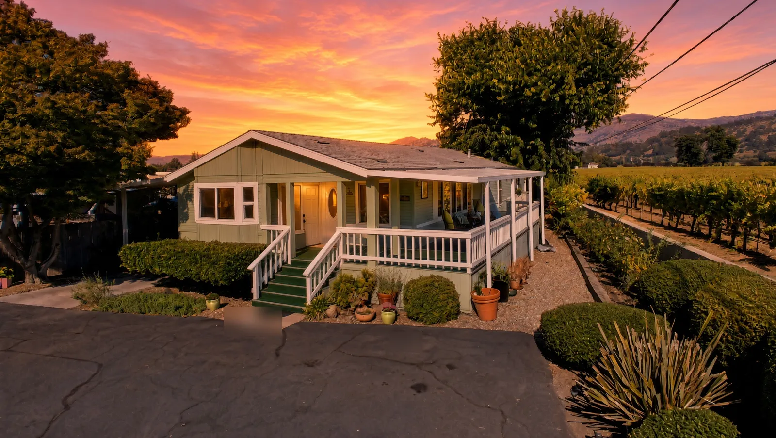 Home exterior at sunset with vineyard behind